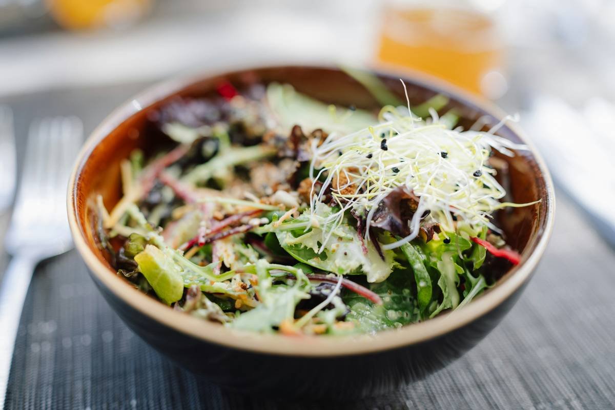 A smiling woman holding a plate of bistroMD food, looking proud of her progress.