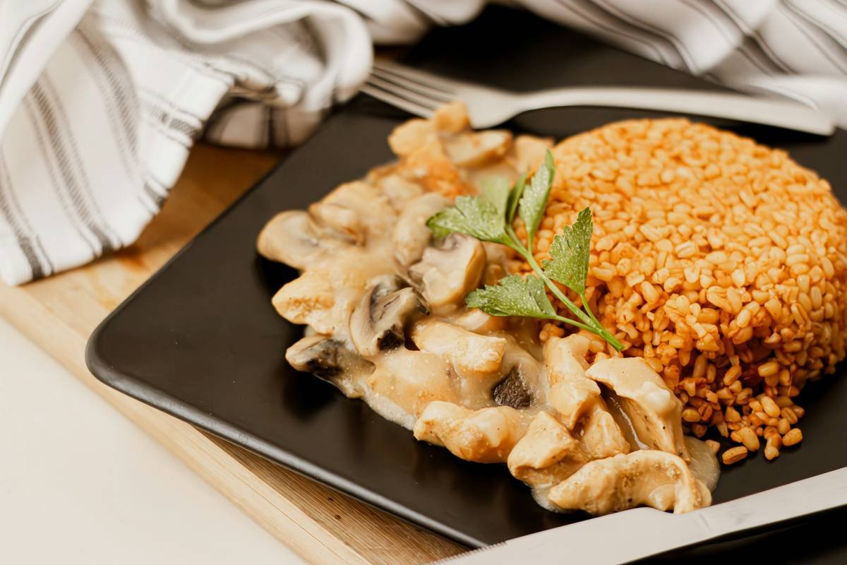 a black plate topped with mushrooms and rice