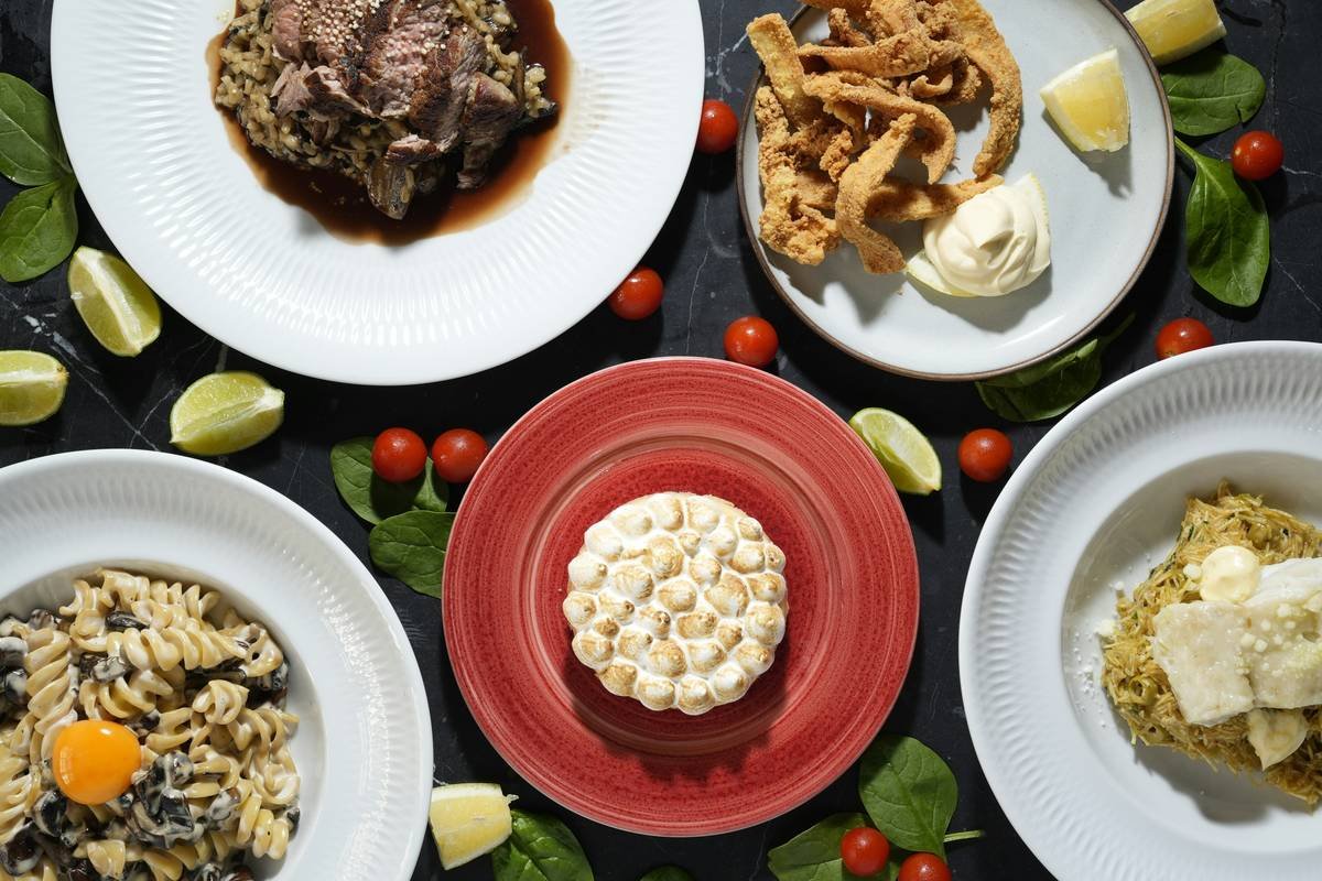 A table topped with plates of food and pasta