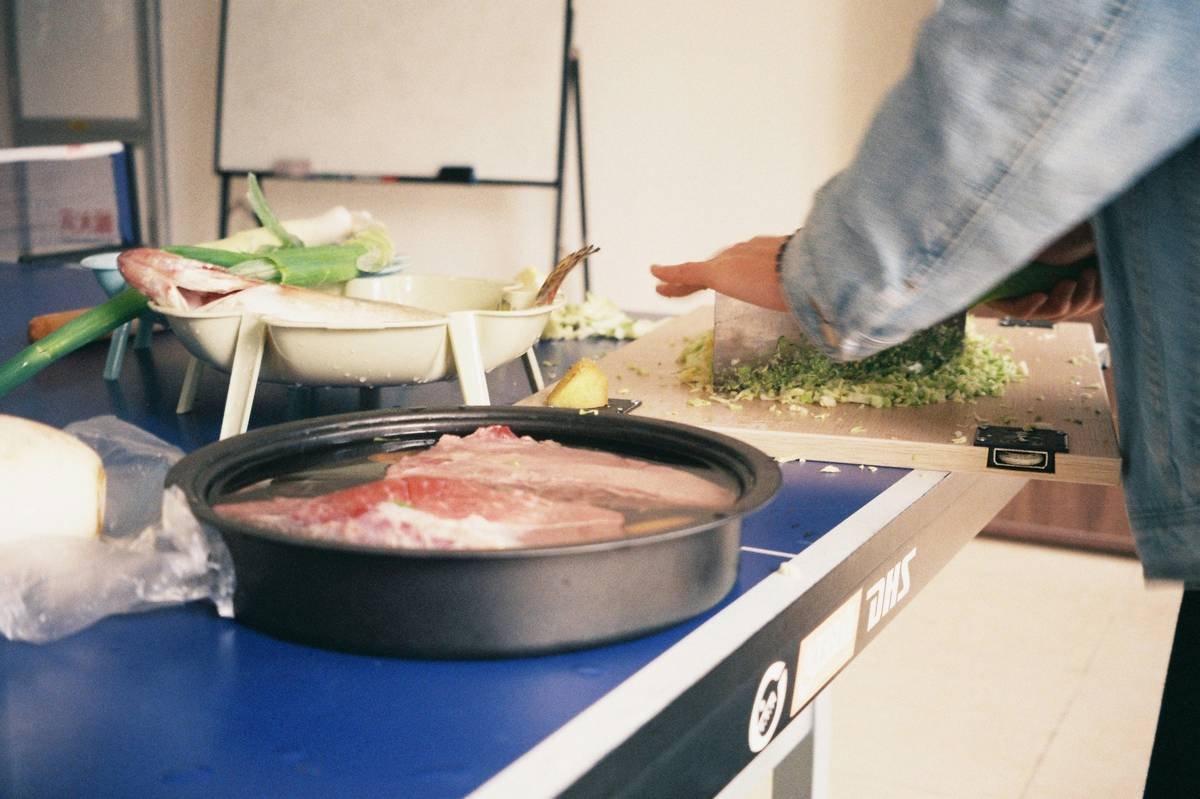 Raw meat soaking in water on a blue surface.