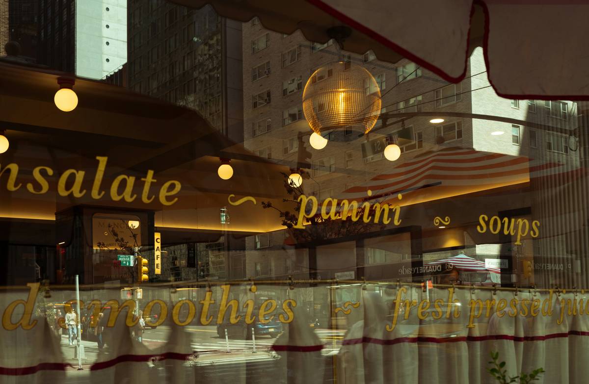 Restaurant window with menu items and reflections