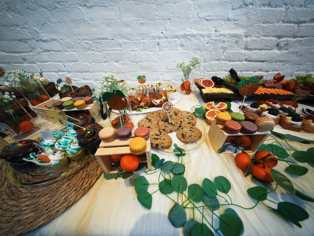 A dessert table with cookies, macarons, and cupcakes