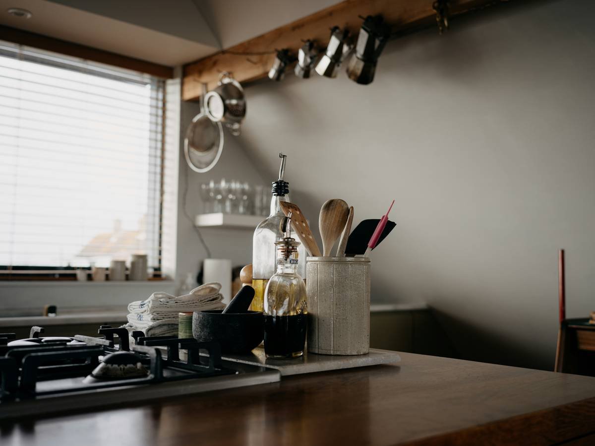 Woman setting up her weekly meal planning routine at kitchen table with notepad and fresh produce